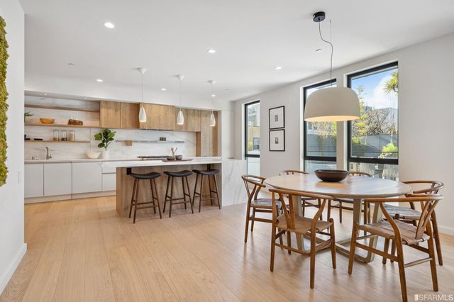 a large kitchen with stainless steel appliances a sink and cabinets