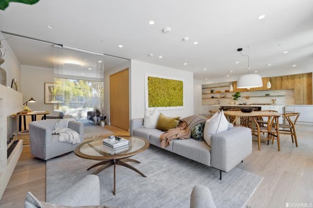 a living room with furniture a large window and a chandelier