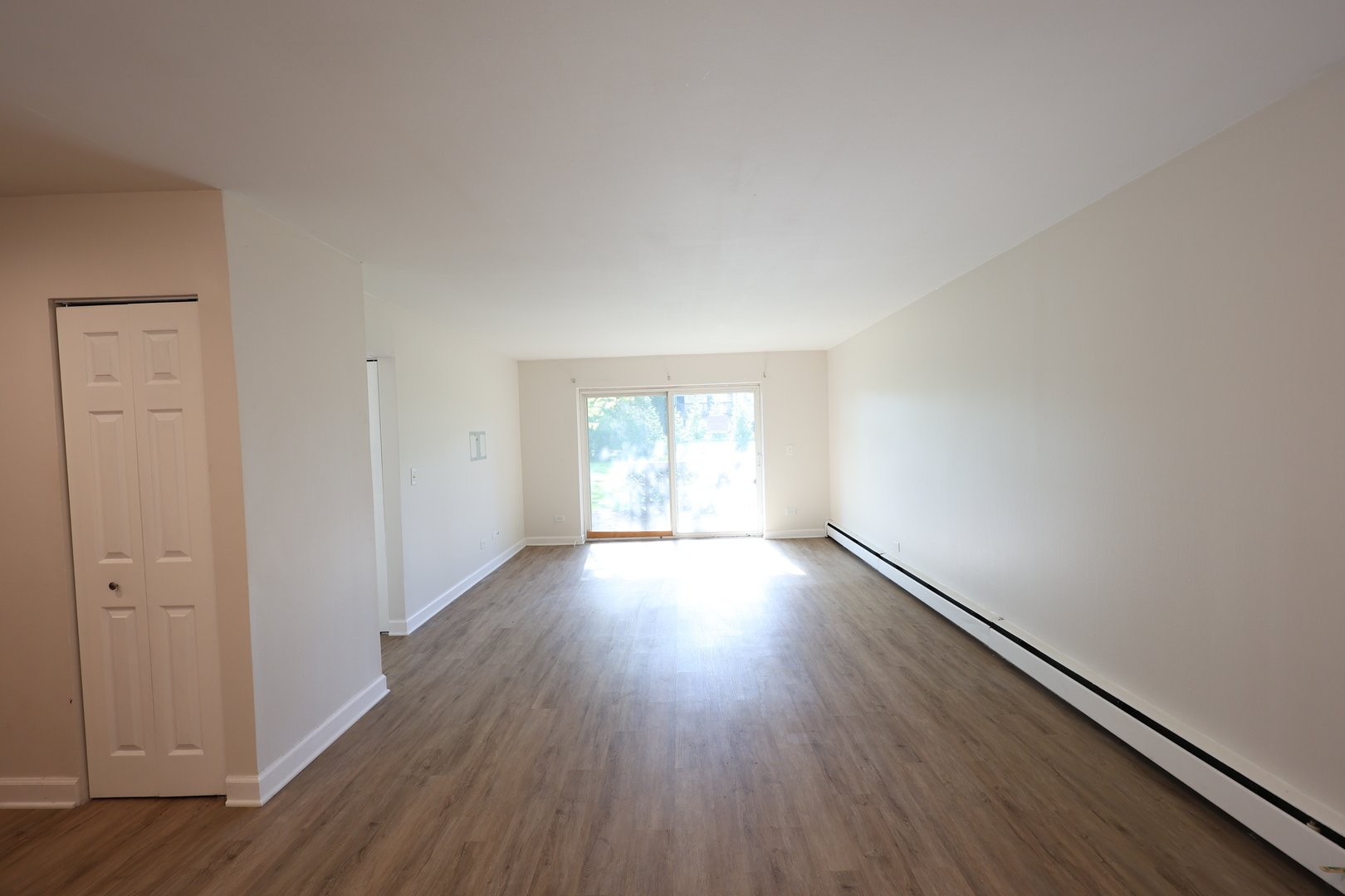 2230 South Goebbert Road, Unit 139 Arlington Heights, IL 60005 - Photo 5 of 14 an empty room with wooden floor and windows