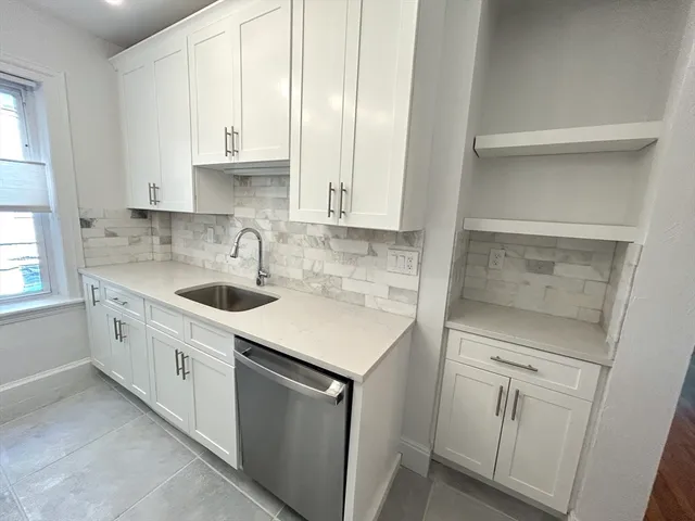 a kitchen with white cabinets and white appliances