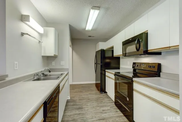 a kitchen with stainless steel appliances a sink dishwasher stove refrigerator and microwave