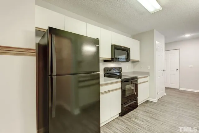 a kitchen with stainless steel appliances granite countertop a refrigerator and a stove