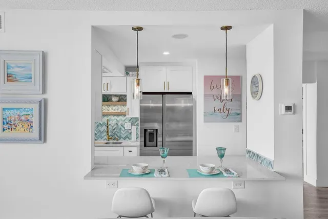 a kitchen with stainless steel appliances granite countertop a refrigerator a oven and white cabinets