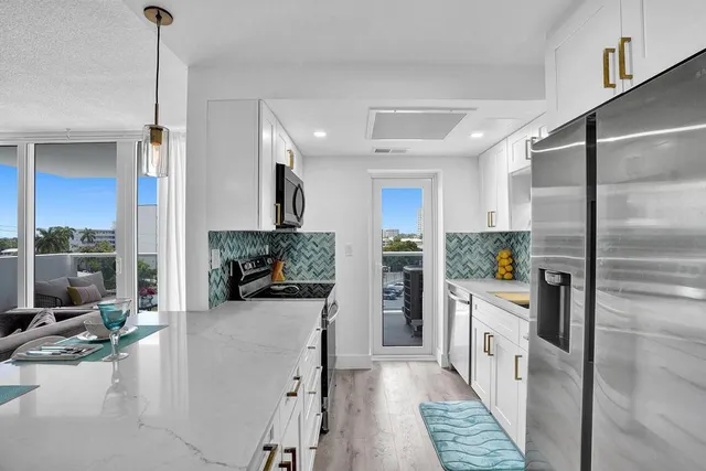 a kitchen with stainless steel appliances kitchen island granite countertop a refrigerator and a stove