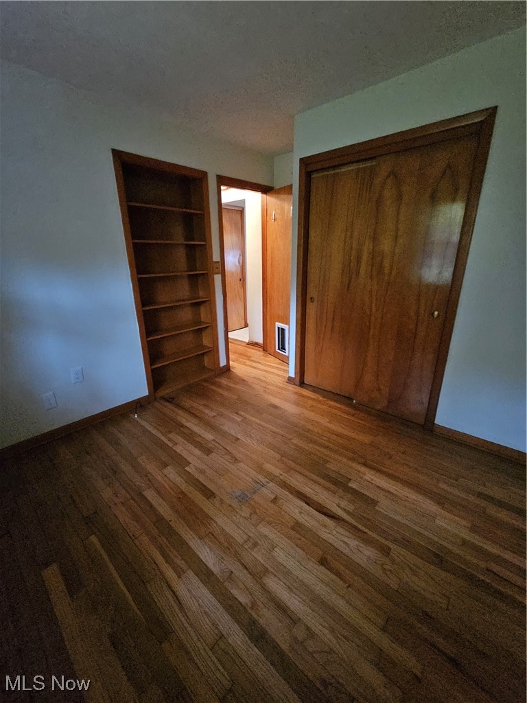 945 West Schaaf Road Cleveland, OH 44109 - Photo 15 of 27 Unfurnished bedroom with a closet, a textured ceiling, and hardwood / wood-style flooring
