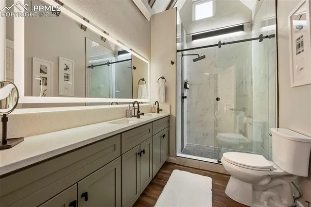 a bathroom with a double vanity sink toilet mirror and shower