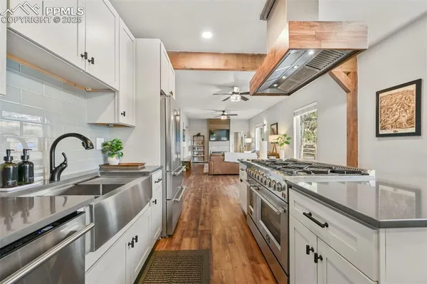 a kitchen with stainless steel appliances granite countertop a stove top oven a sink a counter space and cabinets