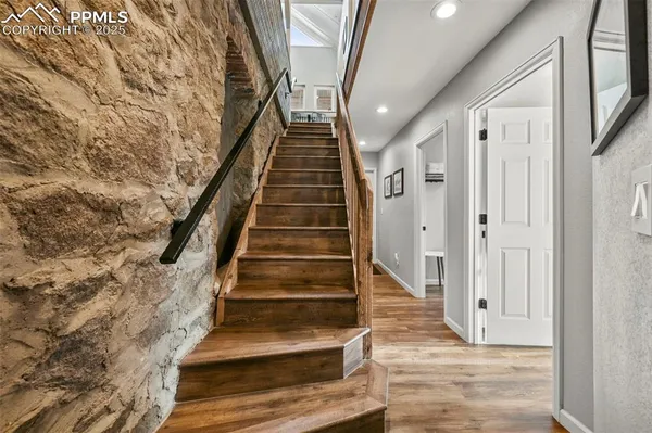 a view of a hallway with wooden floor and entryway