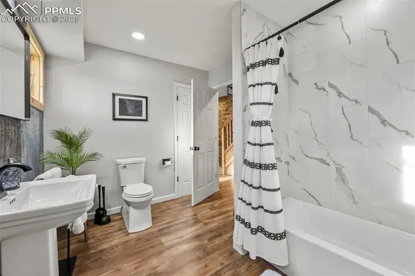 a bathroom with a sink a toilet and shower