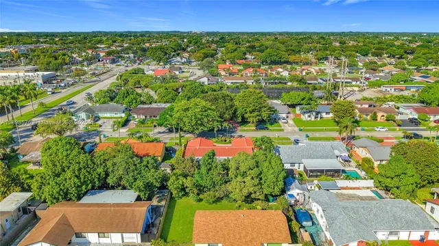 an aerial view of residential houses with outdoor space and trees