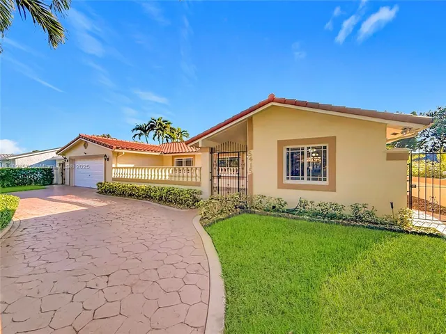 a front view of a house with a garden