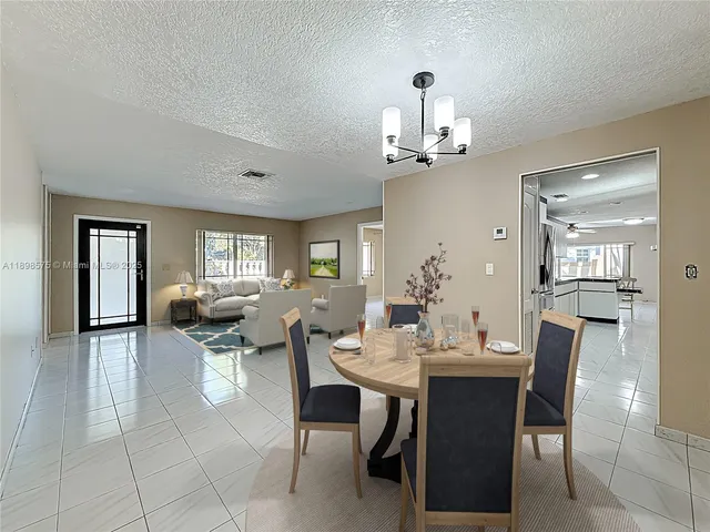 a view of a dining room with furniture and chandelier