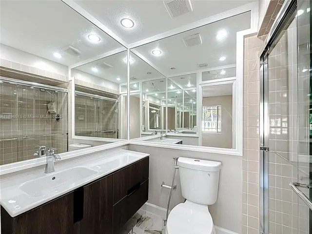 a bathroom with a double vanity sink toilet and shower