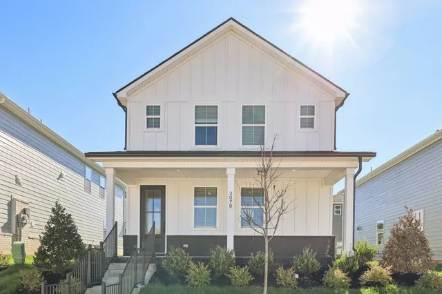 a view of a white house next to a yard
