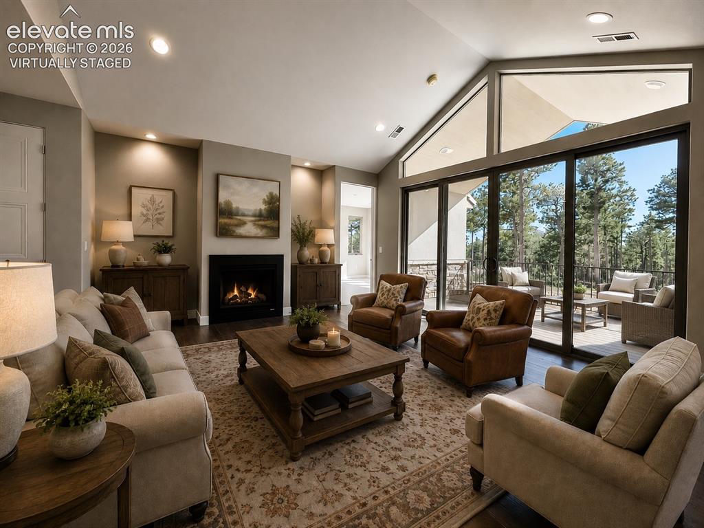 3145 Promise Point Colorado Springs, CO 80921 - Photo 6 of 28 Vaulted Living Room with Gas Fireplace, Wood Flooring, and Oversized Double Sliding Doors. Virtually Staged.
