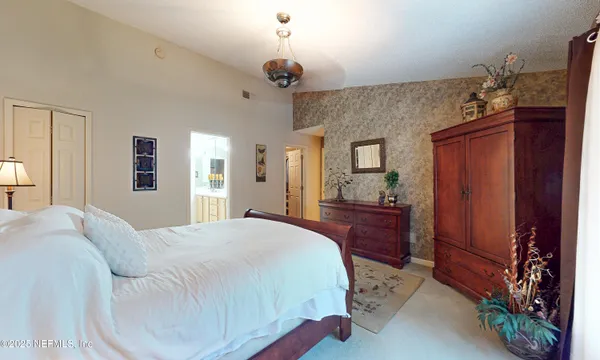 a spacious bedroom with a bed and a chandelier