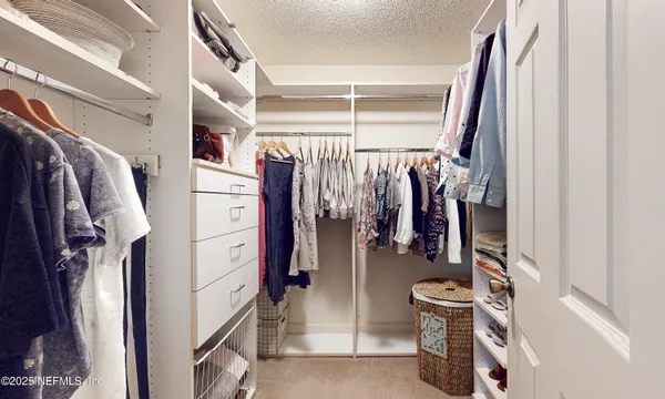 a spacious bedroom with a bed and a dresser