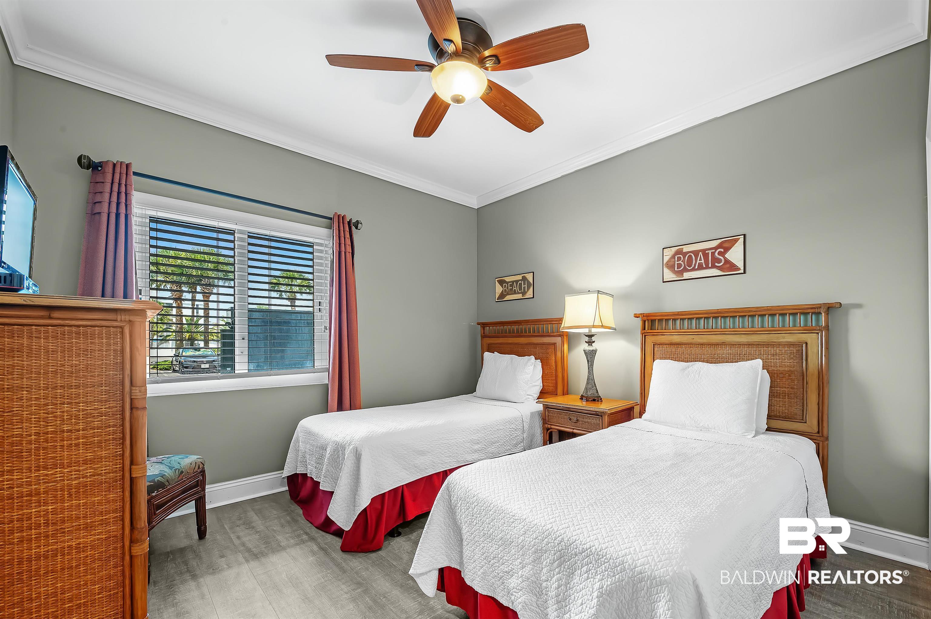 16287 Perdido Key Drive, Unit 105 Pensacola, FL 32507 - Photo 35 of 66 Bedroom featuring two beds with wood headboards, light gray walls, and wood-finish flooring
