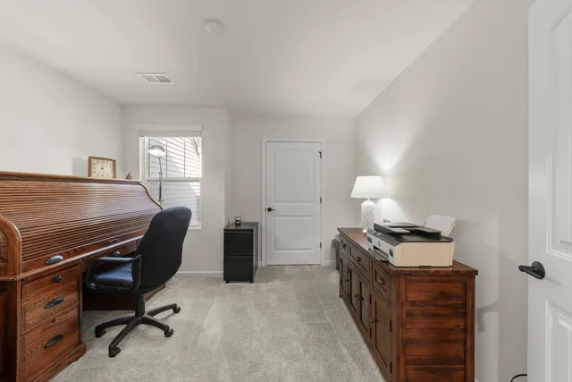 a view of a workspace with furniture and a window