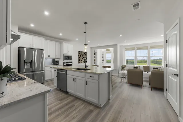 a kitchen with counter top space sink stainless steel appliances and windows
