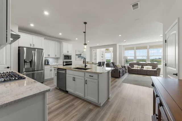 a kitchen with refrigerator a sink and chairs
