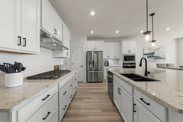 a large kitchen with stainless steel appliances kitchen island granite countertop a sink and cabinets