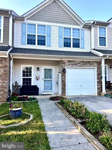 a front view of a house with a yard and potted plants