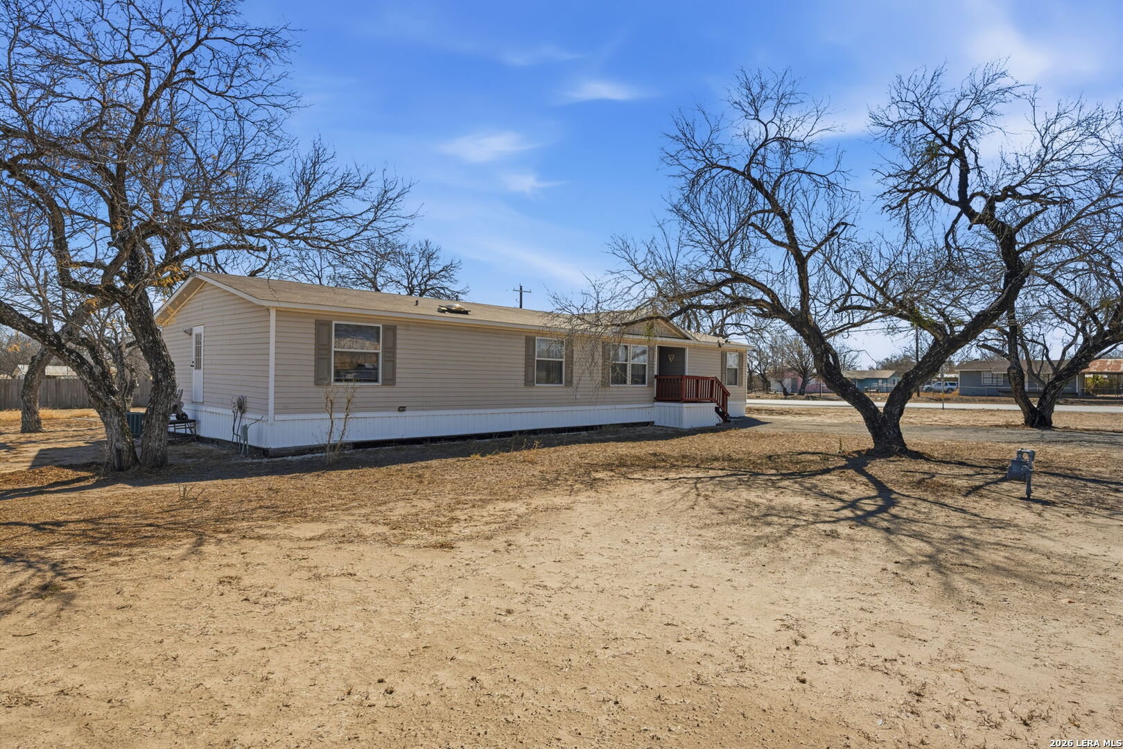 708 Mesquite Street Jourdanton, TX 78026 - Photo 2 of 49 a backyard of a house with large trees