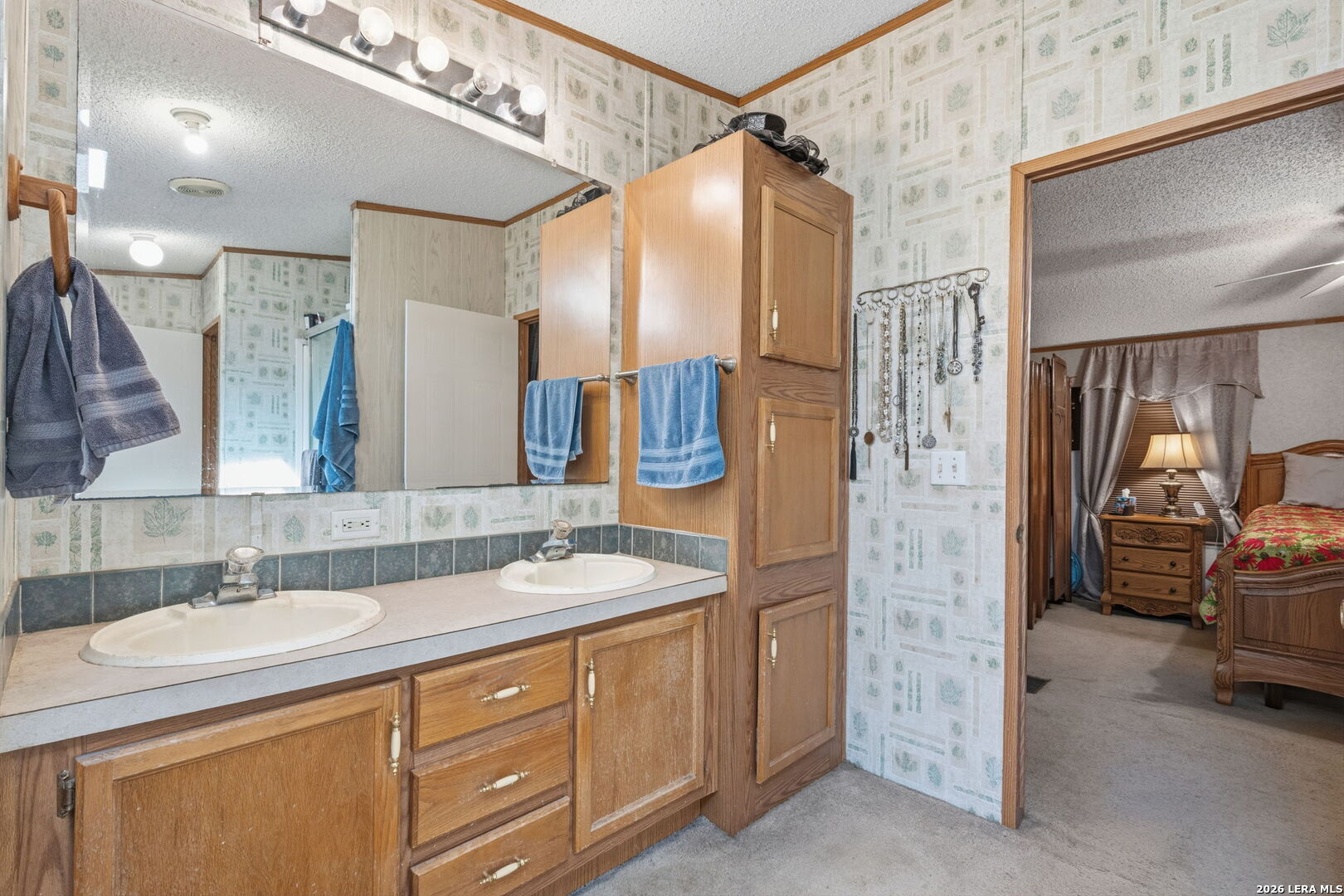 708 Mesquite Street Jourdanton, TX 78026 - Photo 23 of 49 a bathroom with a double vanity sink and a mirror