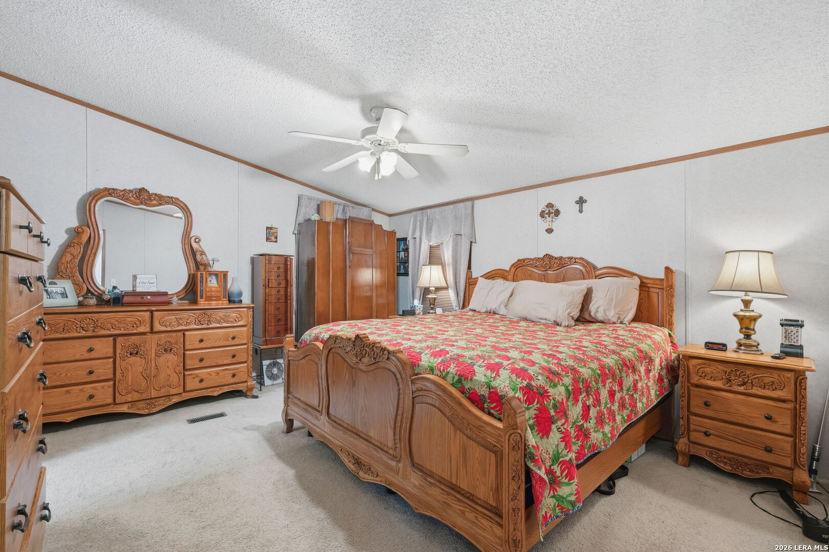 708 Mesquite Street Jourdanton, TX 78026 - Photo 10 of 49 a bedroom with a bed and dresser with mirror