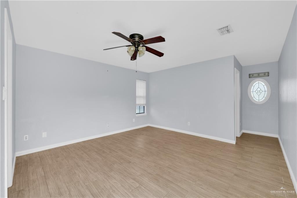 314 Santa Ana Avenue Rancho Viejo, TX 78575 - Photo 11 of 30 a view of a room with wooden floor and ceiling fan