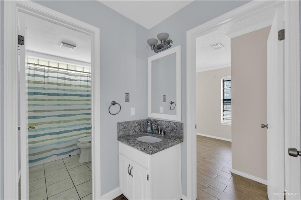 314 Santa Ana Avenue Rancho Viejo, TX 78575 - Photo 14 of 30 a bathroom with a granite countertop sink and a mirror