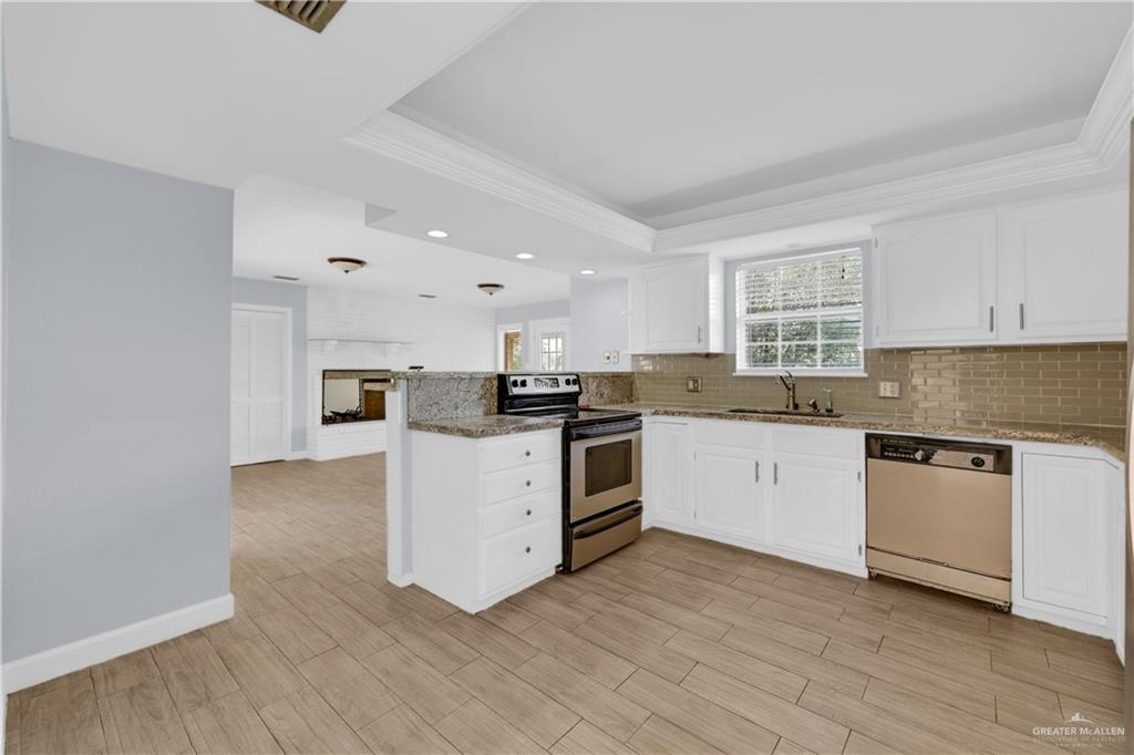 314 Santa Ana Avenue Rancho Viejo, TX 78575 - Photo 8 of 30 a kitchen with granite countertop white cabinets and white appliances