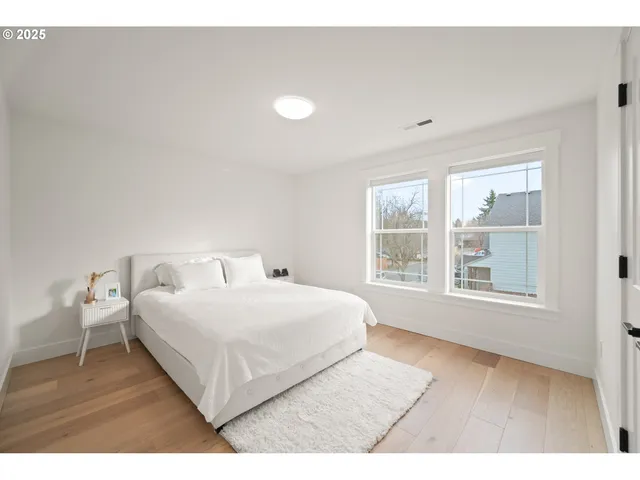 a white bed sitting in a room next to a window