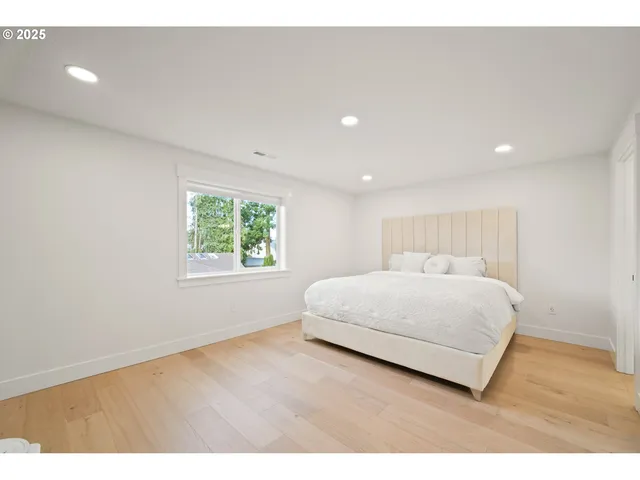 a bedroom with a bed and a large window