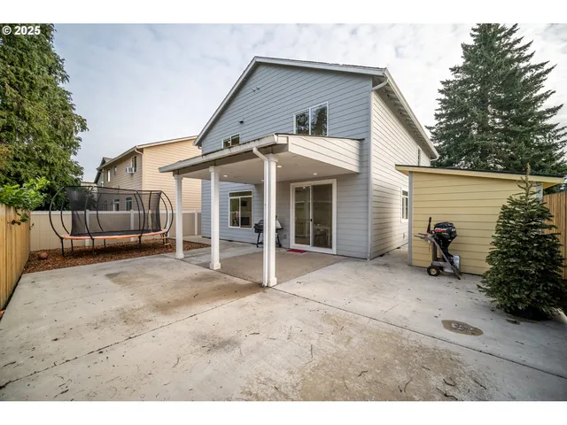 a view of a swimming pool with a patio and a wooden fence