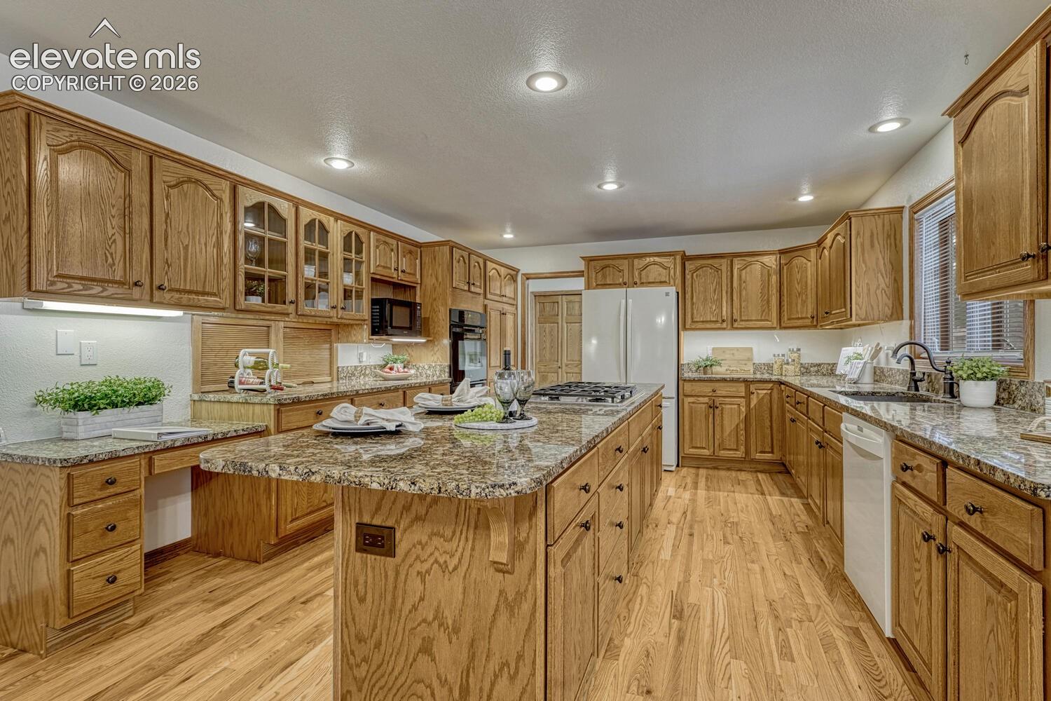 15430 Bar X Road Colorado Springs, CO 80908 - Photo 20 of 50 Abundant wood cabinetry with granite countertops for kitchen storage and easy food preparation.