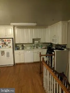 a kitchen with stainless steel appliances a refrigerator sink and white cabinets