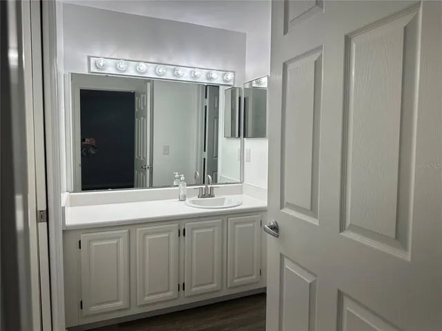 a bathroom with a granite countertop toilet a sink and mirror
