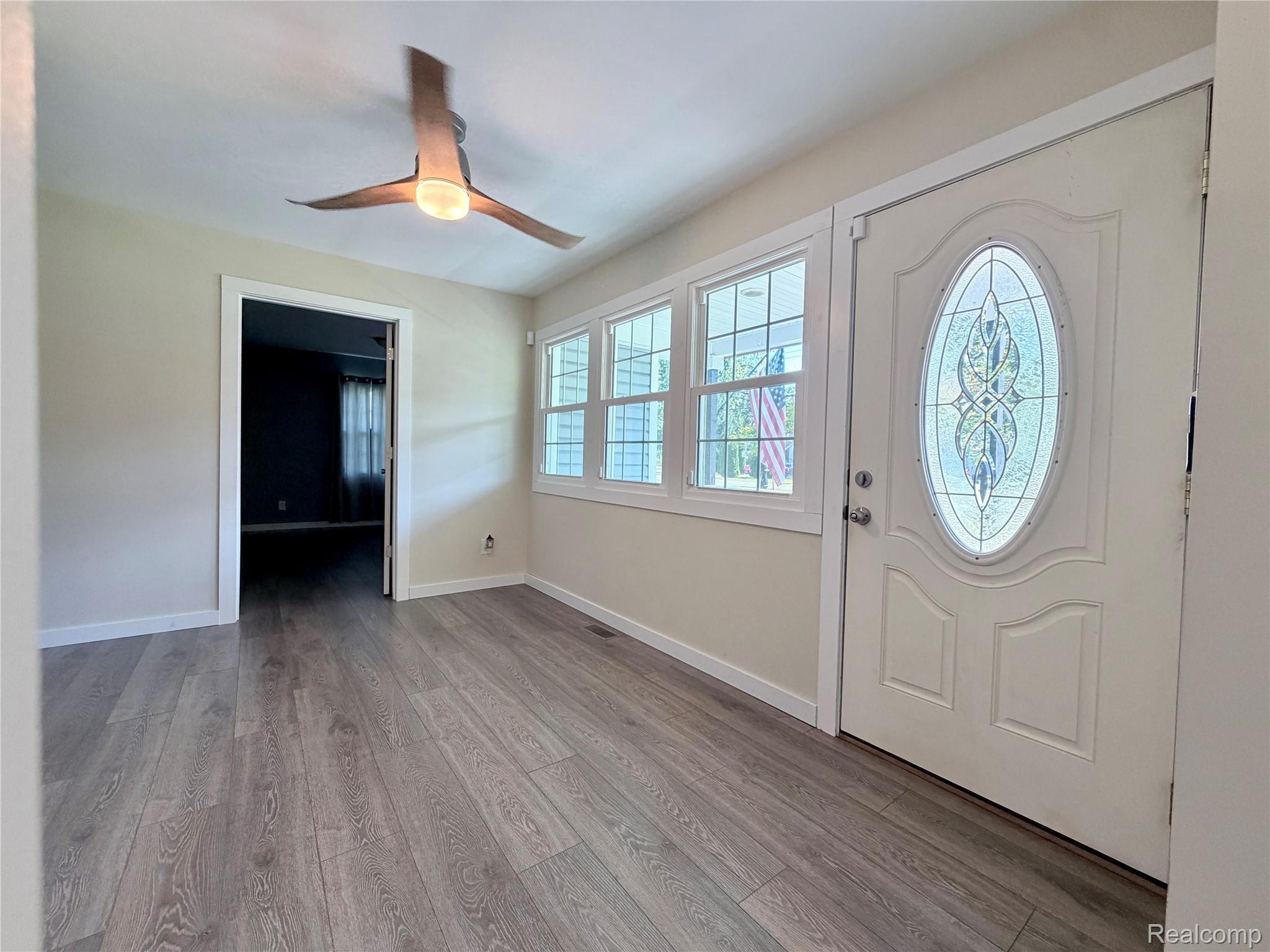 1295 Allen Road Smiths Creek, MI 48074 - Photo 5 of 28 Entryway featuring wood-finish flooring, a decorative front door with an oval leaded glass insert, and a row of windows providing natural light