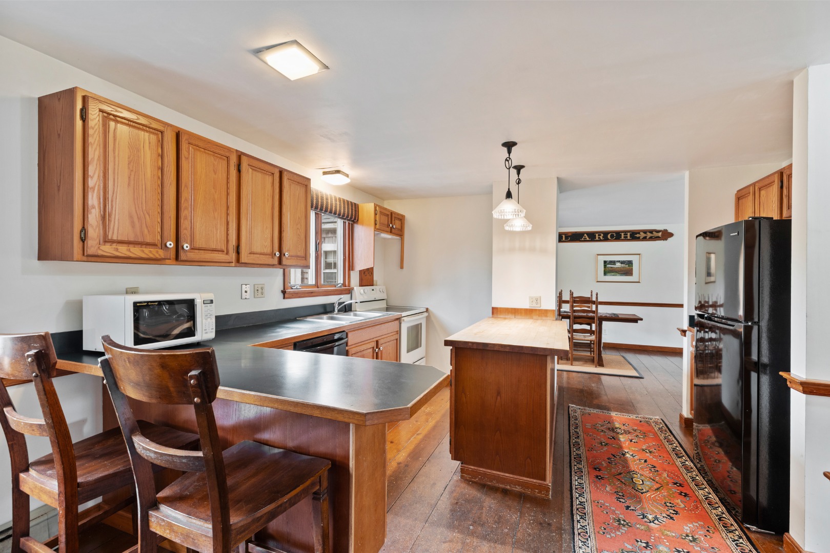 137 Surfside Road Nantucket, MA 02554 - Photo 8 of 24 a kitchen with granite countertop a sink refrigerator and cabinets