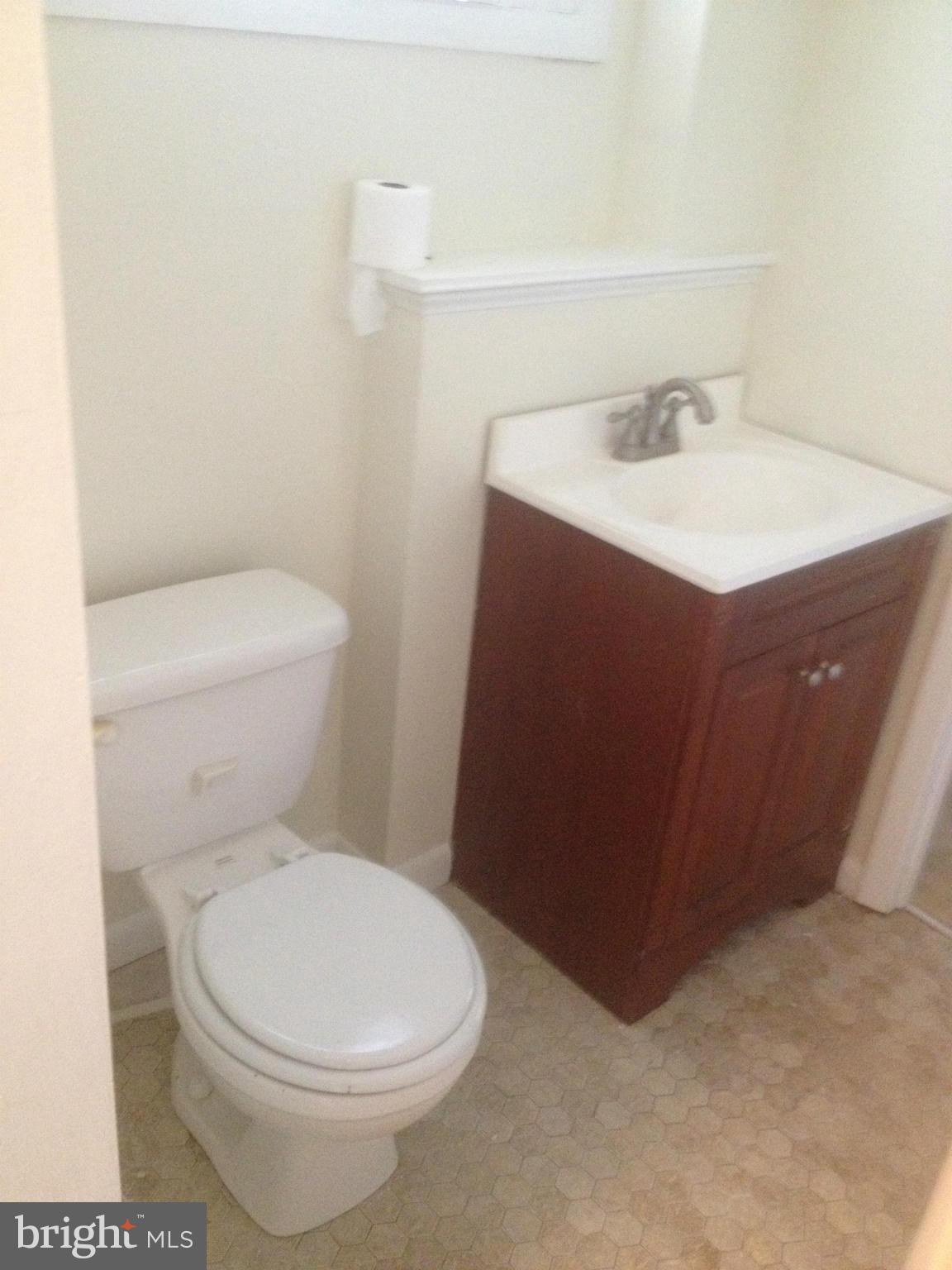 4600 Hawksbury Road Pikesville, MD 21208 - Photo 7 of 17 a white toilet sitting next to a bathroom sink