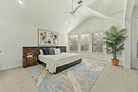 a spacious bedroom with a large bed and a potted plant