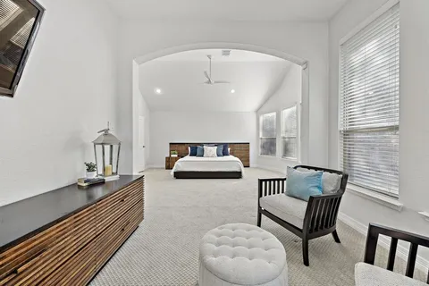 a bedroom with furniture and a large window