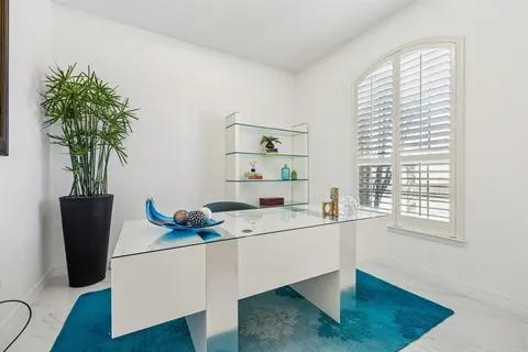 a dining room with furniture and a potted plant