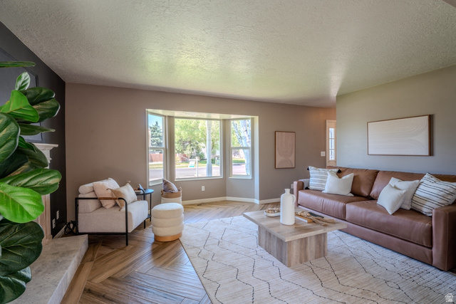 11957 Noelle Road Sandy, UT 84092 - Photo 13 of 38 Living area featuring a bay window, wood-finish flooring, and a fireplace with a mantel
