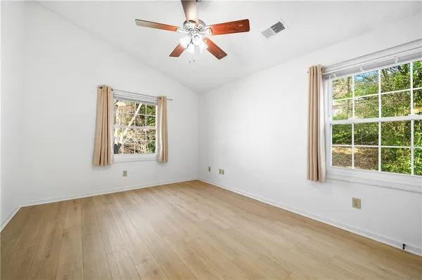 an empty room with a window and a ceiling fan