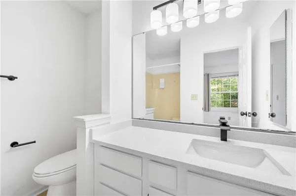 a bathroom with a sink a toilet and a mirror