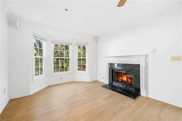 a view of an empty room with a fireplace and window
