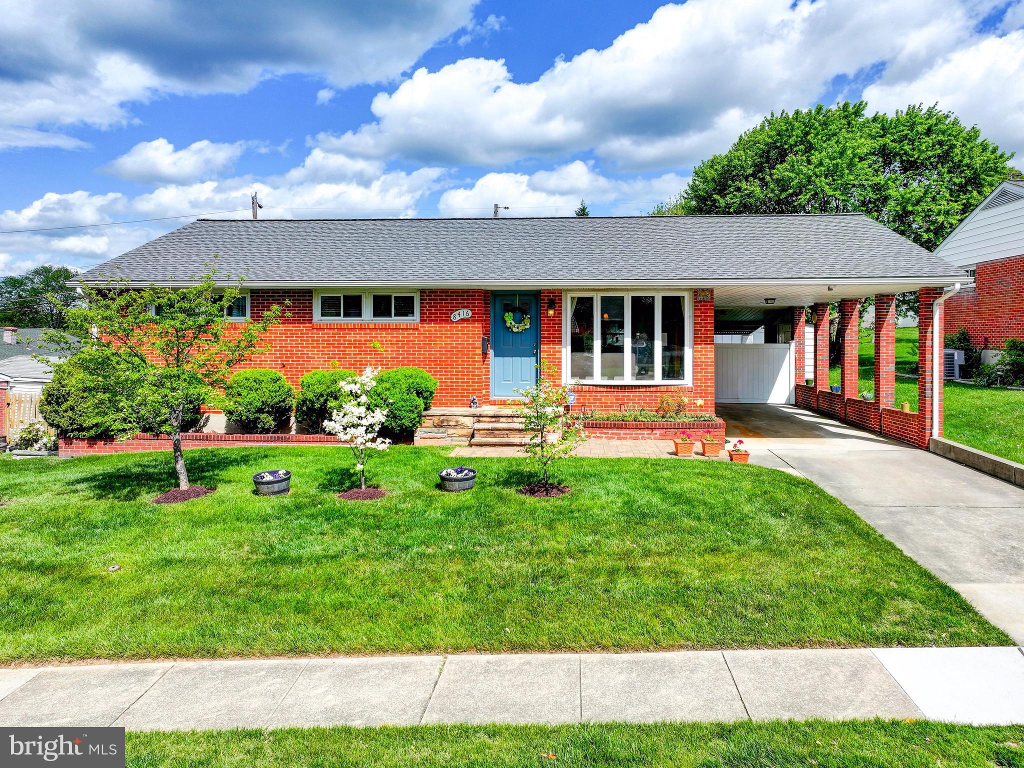 Charming brick home with lush greenery.